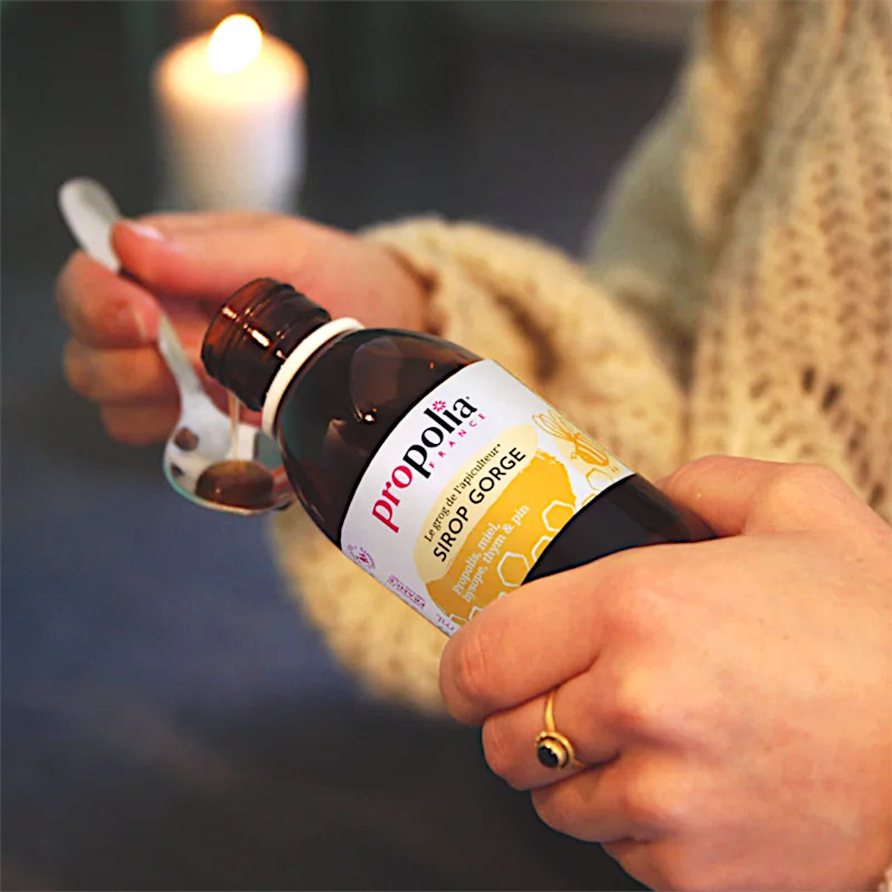 Frau füllt einen Teelöffel Halssirup ab